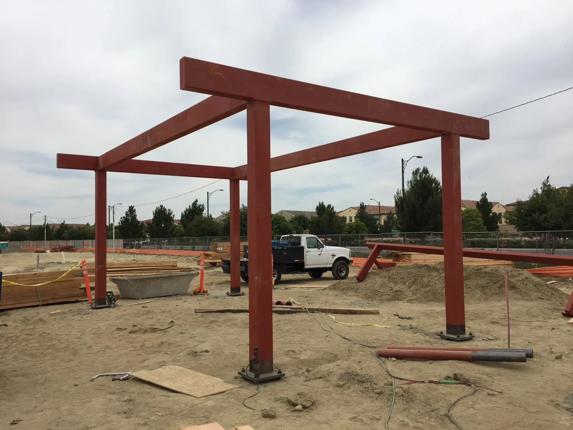 A construction site with some red beams and a truck