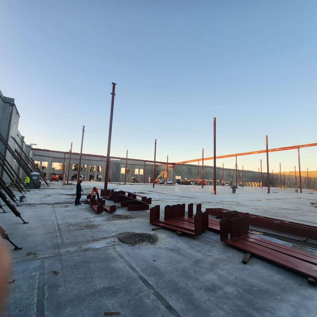 A large building with many metal beams on the ground.